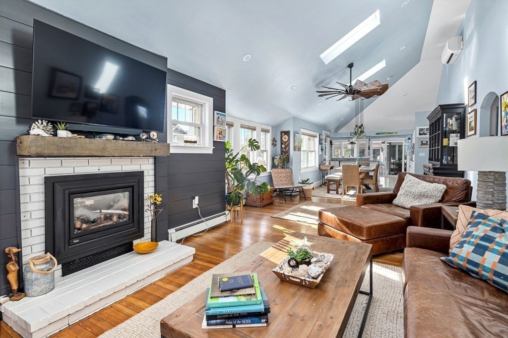 103 Newport Road Hull, MA 02045 - Photo 4 of 40 a living room with furniture a flat screen tv and a fireplace