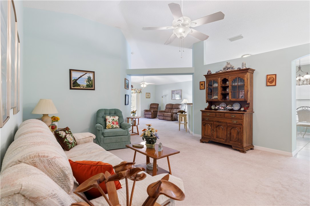 594 Cottonwood Road Sebastian, FL 32958 - Photo 4 of 27 a living room with furniture a rug and a ceiling fan