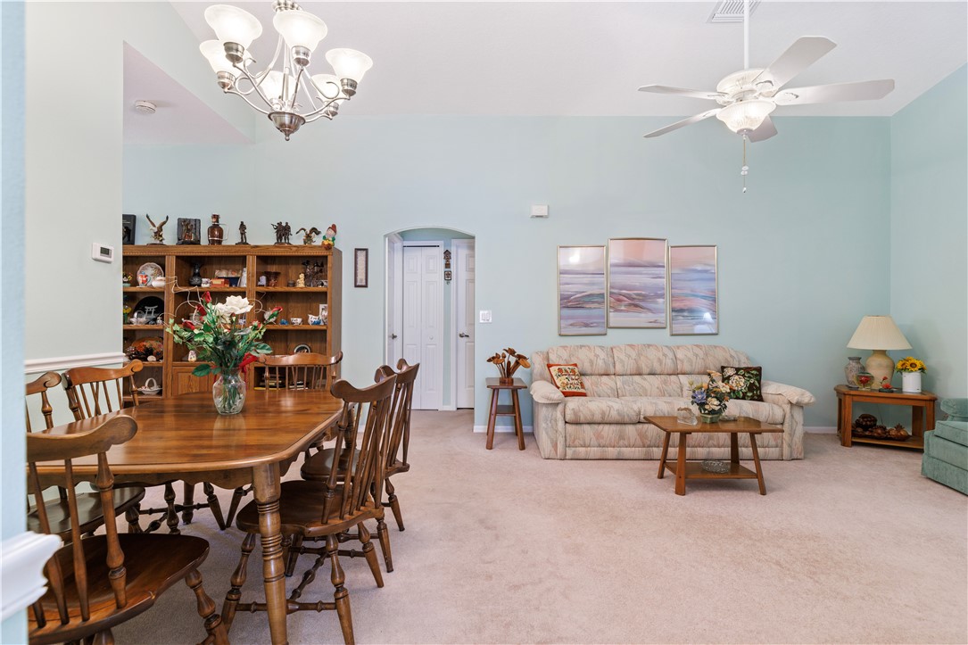594 Cottonwood Road Sebastian, FL 32958 - Photo 5 of 27 a dining room with furniture a chandelier and a rug
