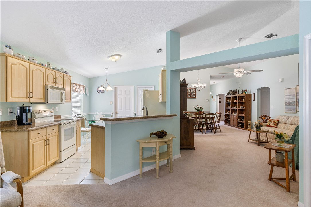 594 Cottonwood Road Sebastian, FL 32958 - Photo 7 of 27 a kitchen with stainless steel appliances kitchen island granite countertop a refrigerator and stove