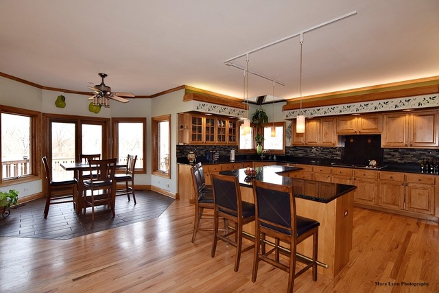 32W546 Rochefort Lane Wayne, IL 60184 - Photo 5 of 25 a kitchen with stainless steel appliances granite countertop table chairs and wooden floor