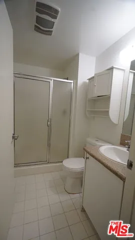 a bathroom with a granite countertop toilet and a sink