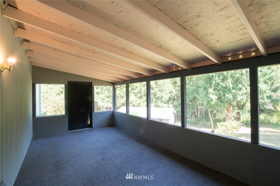 465 Guy Kelly Road Port Angeles, WA 98362 - Photo 13 of 31 a view of an empty room with a fireplace and large windows