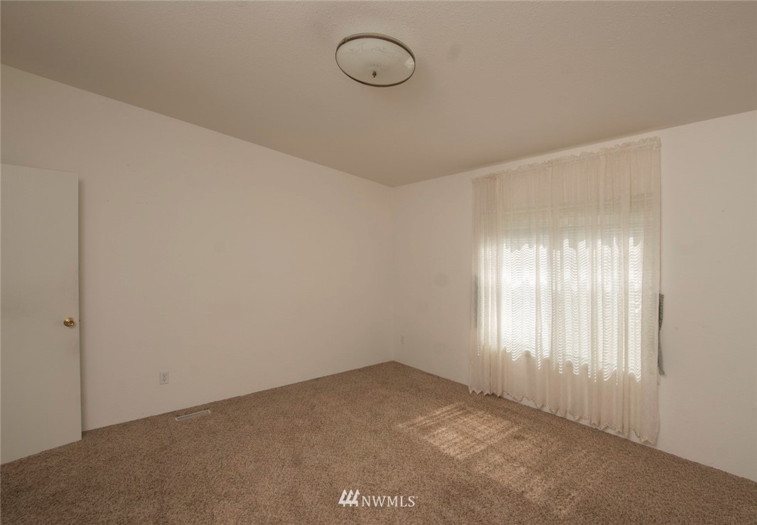 465 Guy Kelly Road Port Angeles, WA 98362 - Photo 17 of 31 a view of an empty room with wooden floor and window