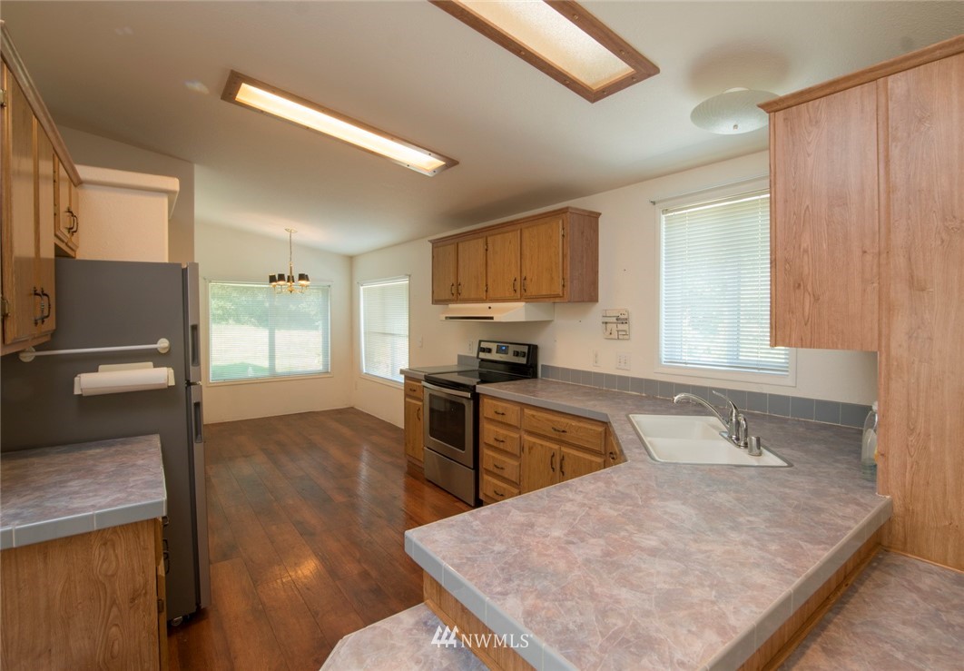 465 Guy Kelly Road Port Angeles, WA 98362 - Photo 8 of 31 a kitchen with stainless steel appliances granite countertop a sink refrigerator and microwave