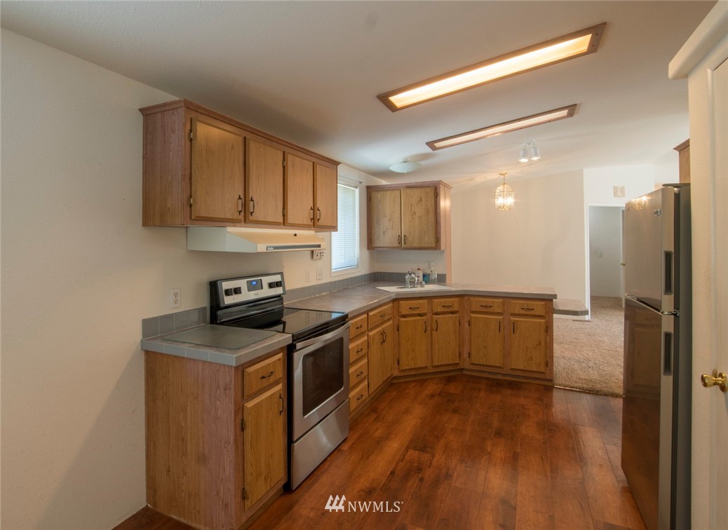 465 Guy Kelly Road Port Angeles, WA 98362 - Photo 10 of 31 a kitchen with stainless steel appliances granite countertop a stove a sink and a refrigerator