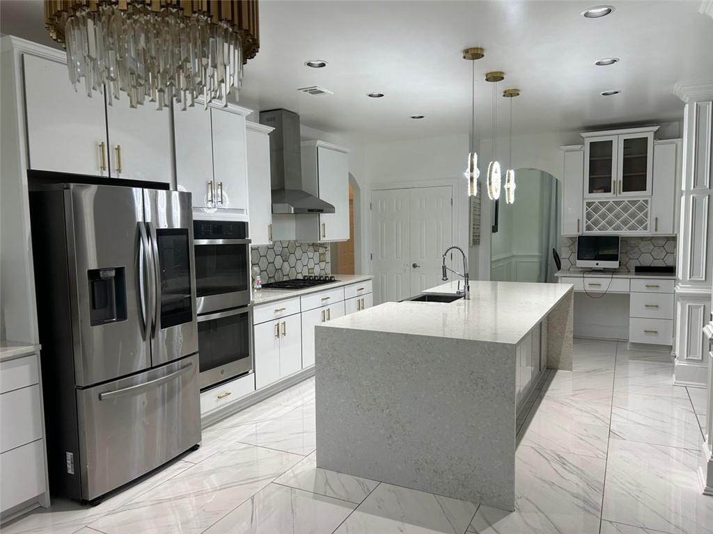 a kitchen with stainless steel appliances a refrigerator a sink a stove and cabinets