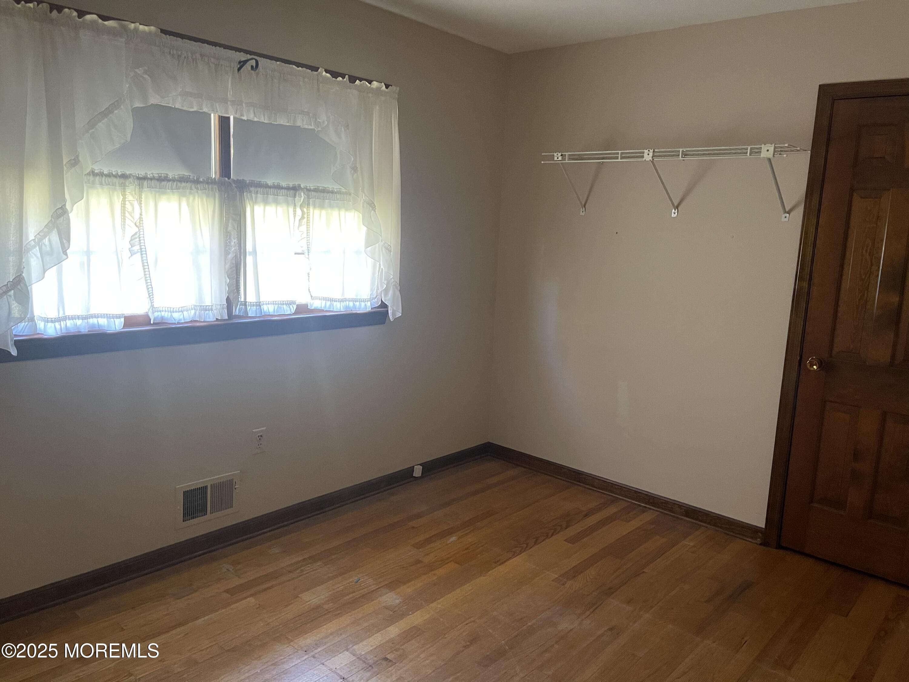 2023 Lanes Mill Road Brick, NJ 08724 - Photo 28 of 40 an empty room with wooden floor and windows