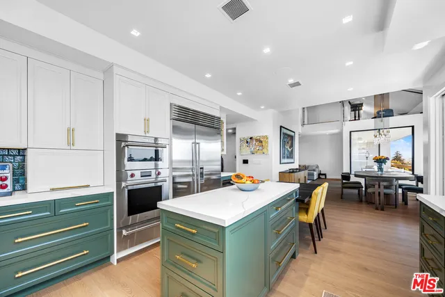 a bedroom with a large bed and a flat tv screen on dresser