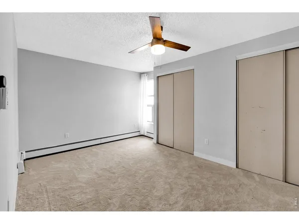 a view of an empty room with a ceiling fan
