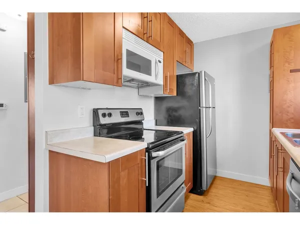 a kitchen with stainless steel appliances granite countertop a refrigerator microwave and sink