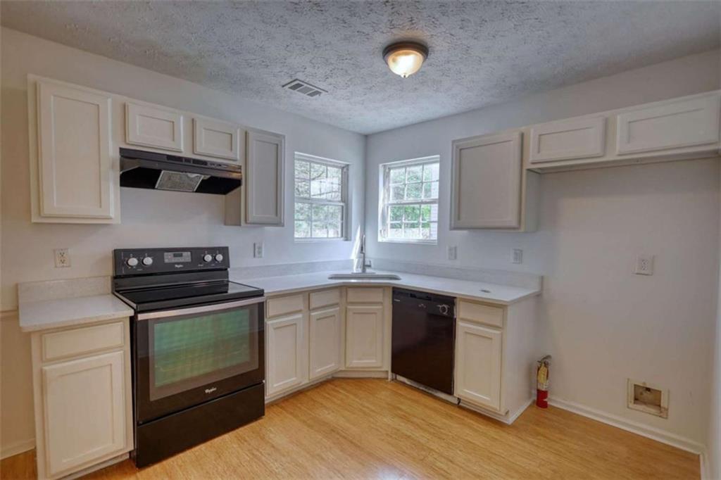 5185 Tew Lane Southwest Covington, GA 30014 - Photo 13 of 42 a kitchen with a sink stove and microwave