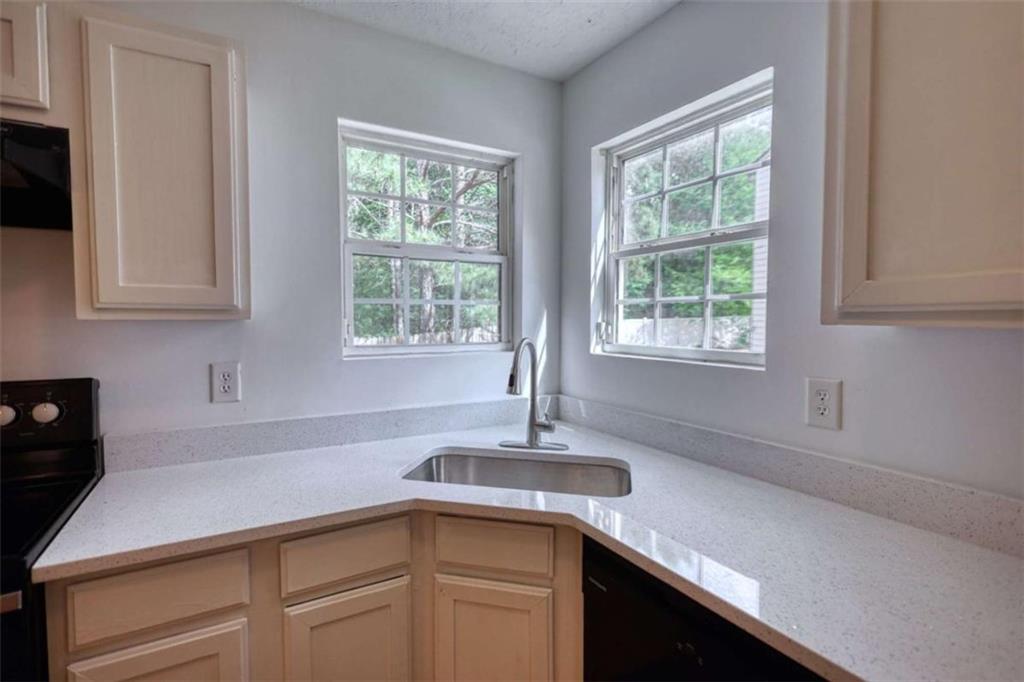 5185 Tew Lane Southwest Covington, GA 30014 - Photo 14 of 42 a kitchen with a sink and cabinets
