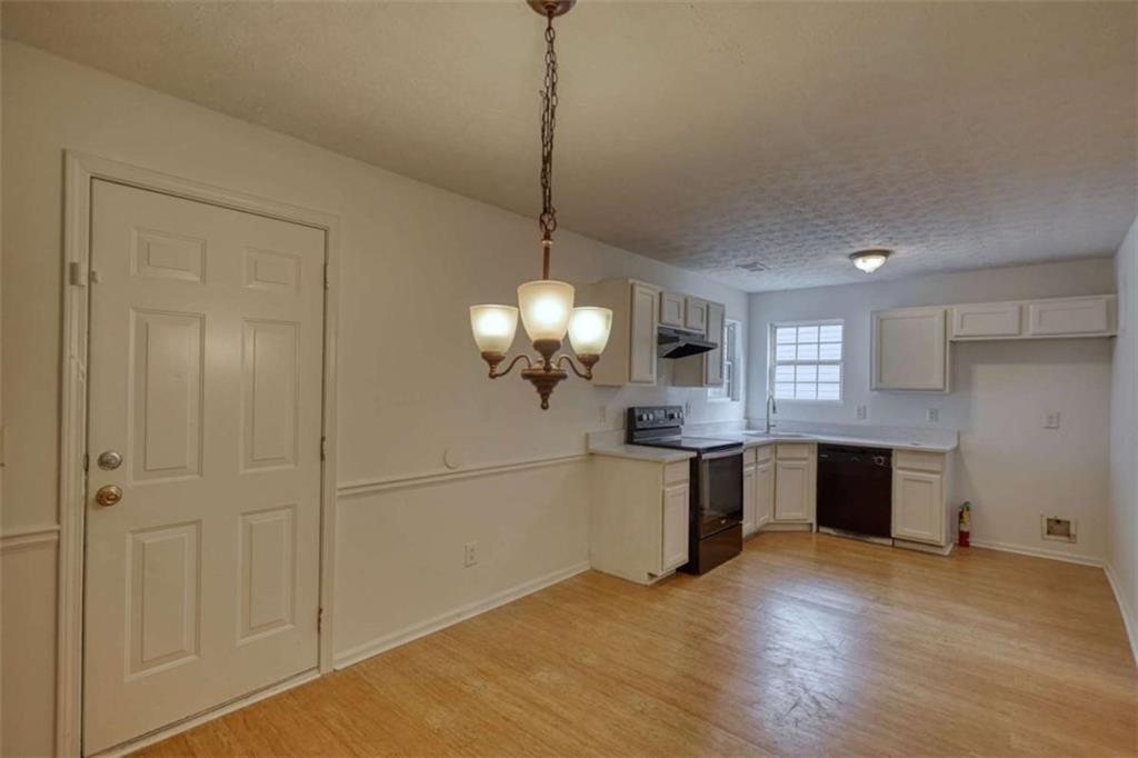 5185 Tew Lane Southwest Covington, GA 30014 - Photo 19 of 42 a large kitchen with chandelier and stainless steel appliances