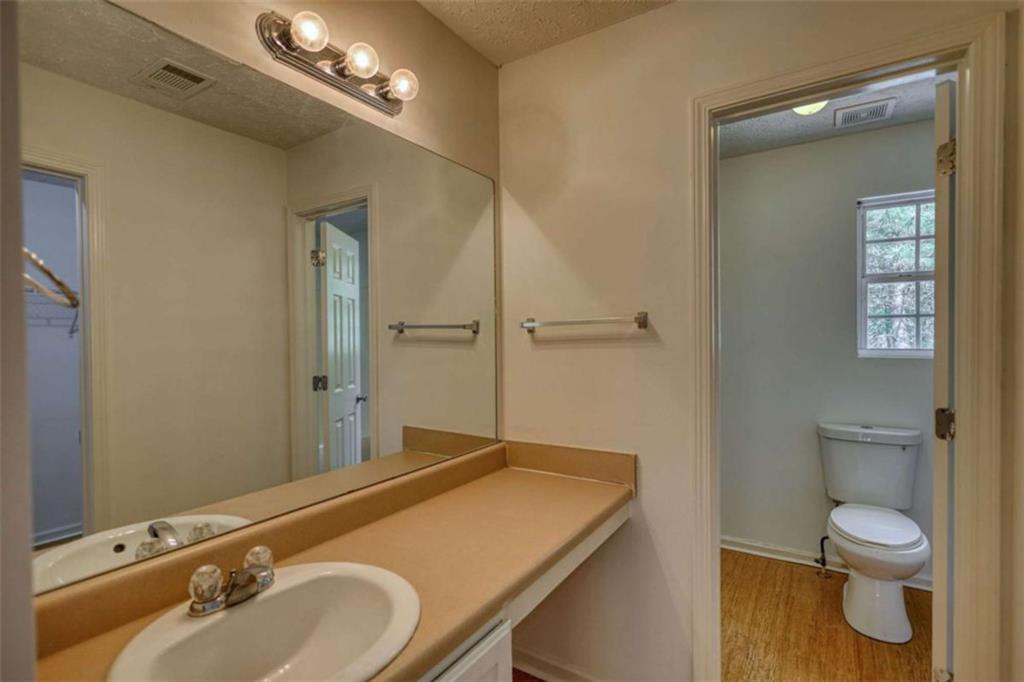 5185 Tew Lane Southwest Covington, GA 30014 - Photo 25 of 42 a bathroom with a granite countertop sink toilet a large mirror and shower