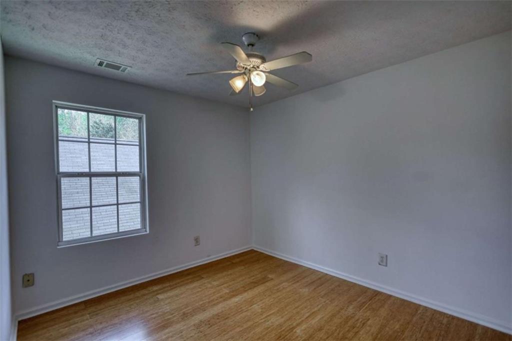 5185 Tew Lane Southwest Covington, GA 30014 - Photo 29 of 42 an empty room with wooden floor fan and windows