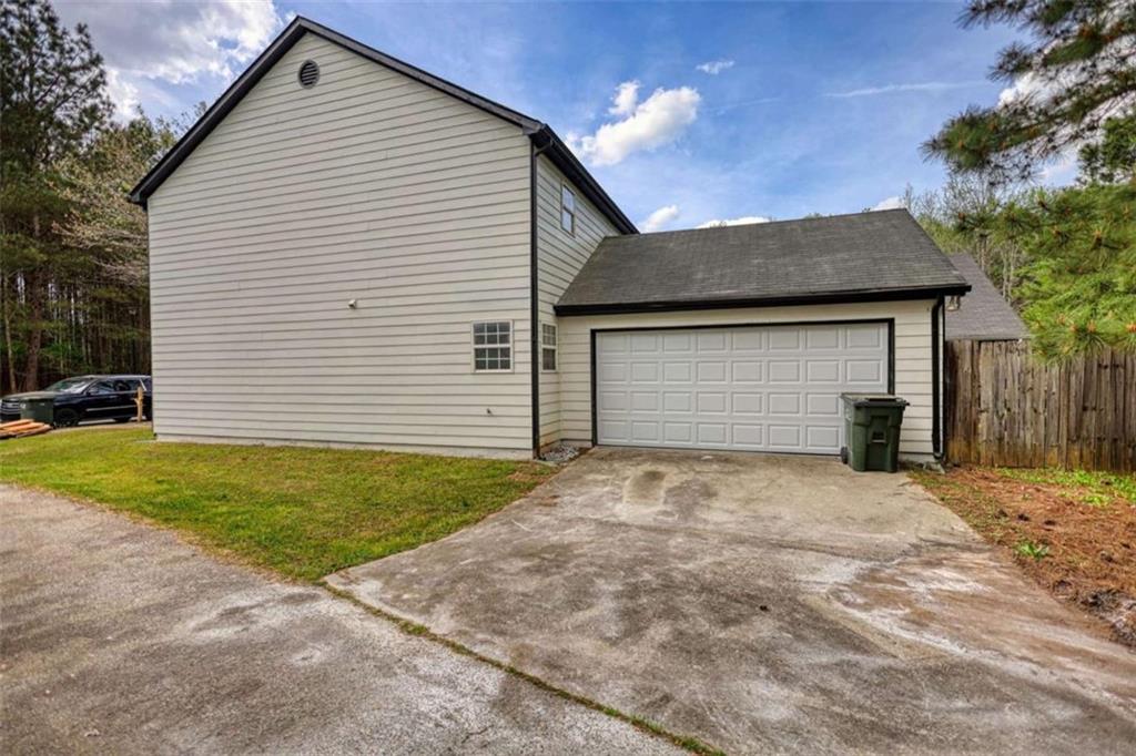 5185 Tew Lane Southwest Covington, GA 30014 - Photo 3 of 42 a front view of a house with a yard and garage
