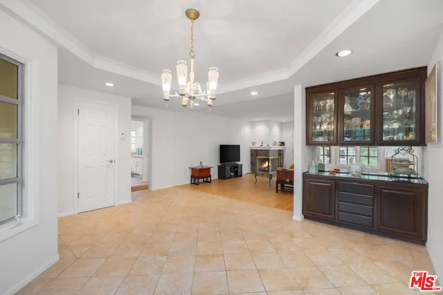a view of a livingroom with furniture a chandelier and window