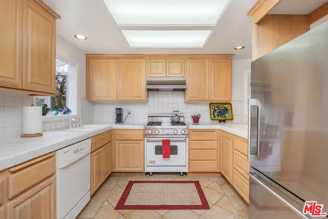 a kitchen with a white cabinets and white appliances