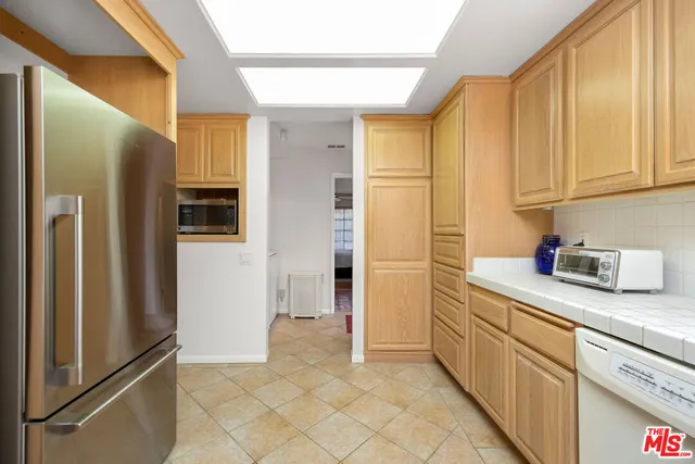 a kitchen with stainless steel appliances granite countertop a refrigerator and a stove