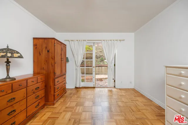 a view of an empty room with cabinet and a window