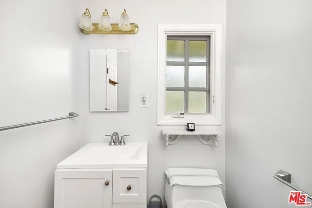 a bedroom with a bed and a flat tv screen on dresser