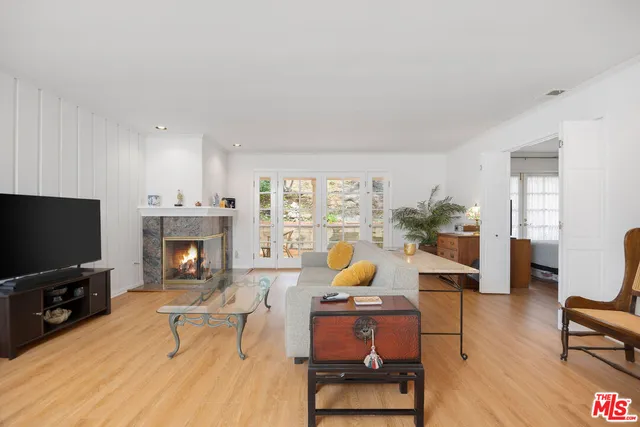 a living room with furniture a fireplace a flat screen tv and a window