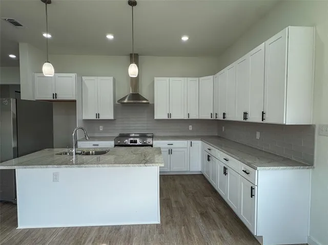 a kitchen with stainless steel appliances granite countertop a sink a stove and a refrigerator