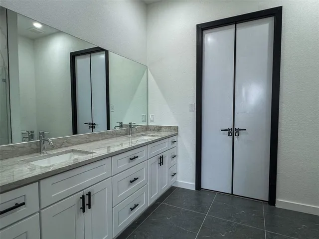 a bathroom with a granite countertop sink and a mirror