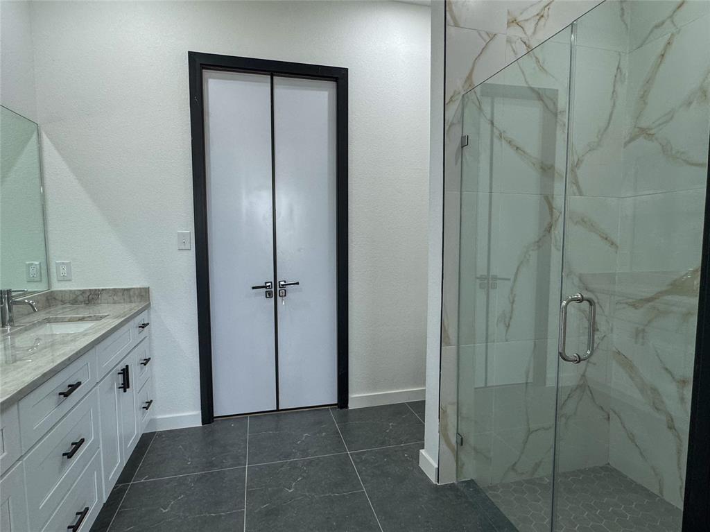 440 Lucy Road Greenville, TX 75402 - Photo 9 of 19 a bathroom with a granite countertop sink a mirror and a shower