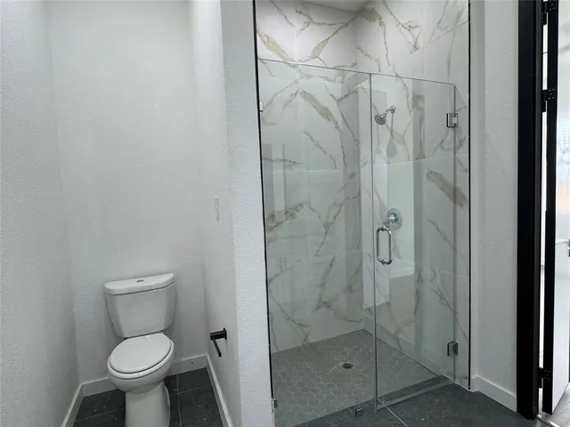 a bathroom with a toilet and a shower