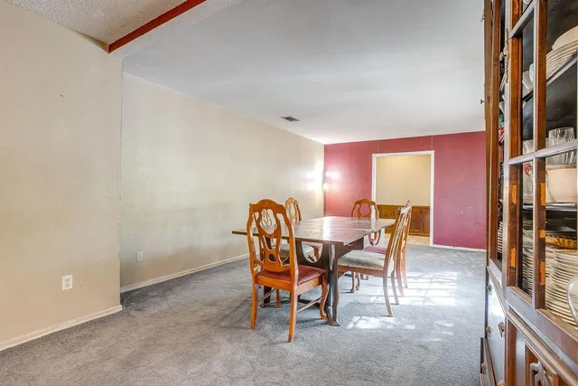 a dining room with furniture and a floor to ceiling window