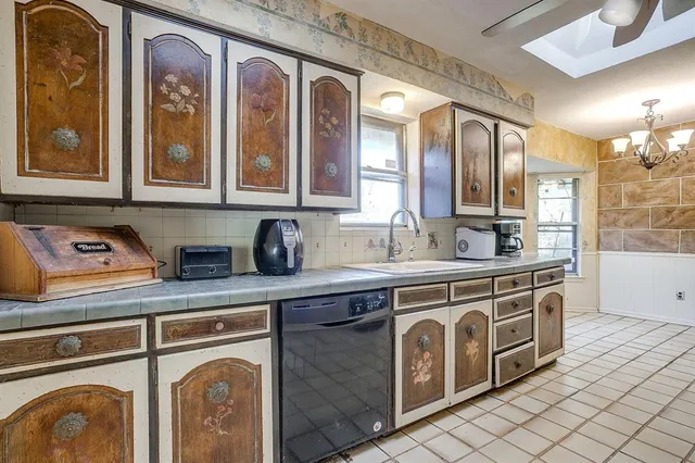 a utility room with stainless steel appliances granite countertop a sink and cabinets