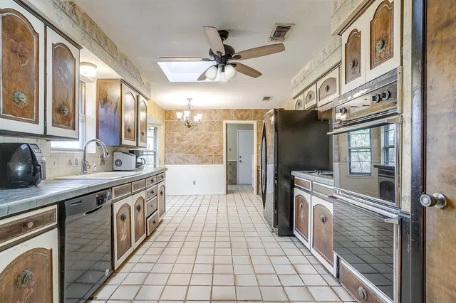 a open kitchen with stainless steel appliances granite countertop a refrigerator and a sink