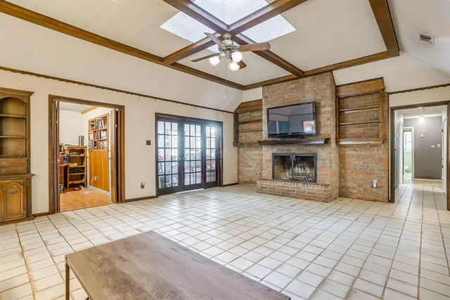a view of an empty room with window and a kitchen