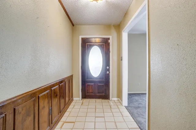 a view of a hallway with wooden floor and a bathroom