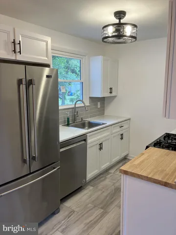 a kitchen with stainless steel appliances a refrigerator a sink a stove and cabinets