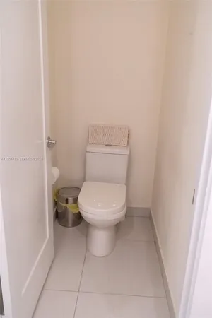 a white toilet sitting next to a white cabinet