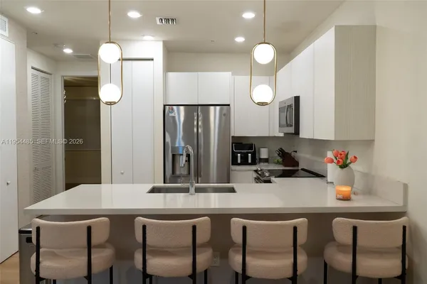 a kitchen with a table chairs sink and refrigerator
