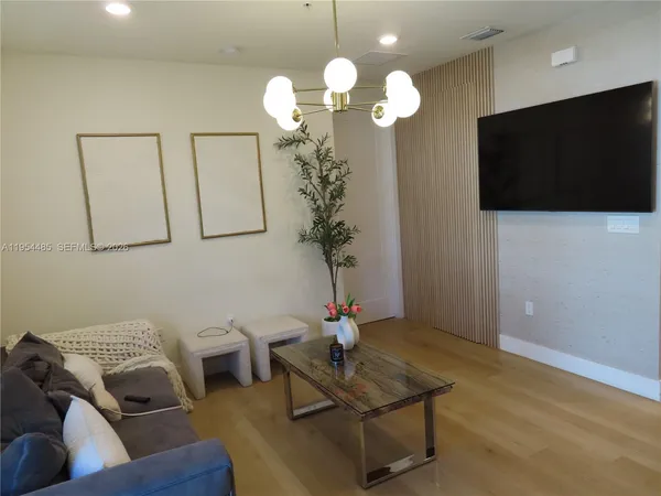 a living room with furniture a flat screen tv and a lamp