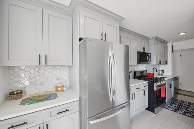 a kitchen with stainless steel appliances a sink a stove and cabinets