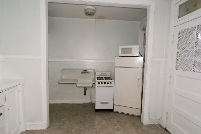 1921 West Winnemac Avenue, Unit 1 Chicago, IL 60640 - Photo 3 of 14 a kitchen with a refrigerator and washer