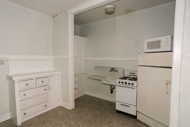 1921 West Winnemac Avenue, Unit 1 Chicago, IL 60640 - Photo 4 of 14 a kitchen with white cabinets and white appliances