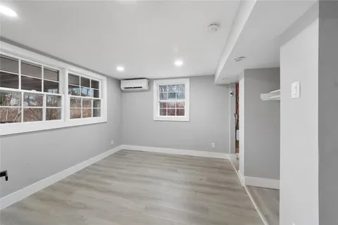 a view of empty room with windows and wardrobe