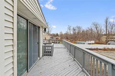 a view of a balcony with wooden floor and wooden fence