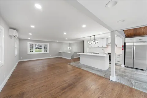 a view of kitchen with kitchen island white cabinets and stainless steel appliances