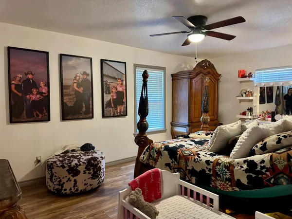 a living room with furniture chess board and a ceiling fan