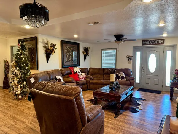 a living room with furniture and a wooden floor