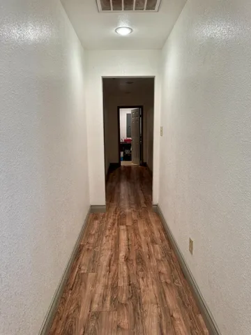 a view of a hallway with wooden floor