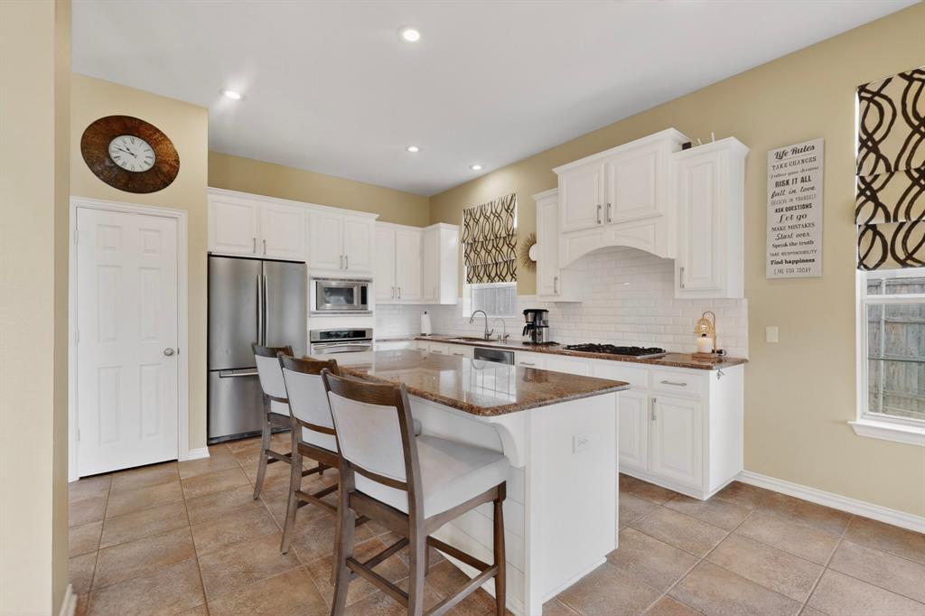 4004 White Porch Road Plano, TX 75024 - Photo 12 of 40 a kitchen with stainless steel appliances a stove a sink a refrigerator and cabinets